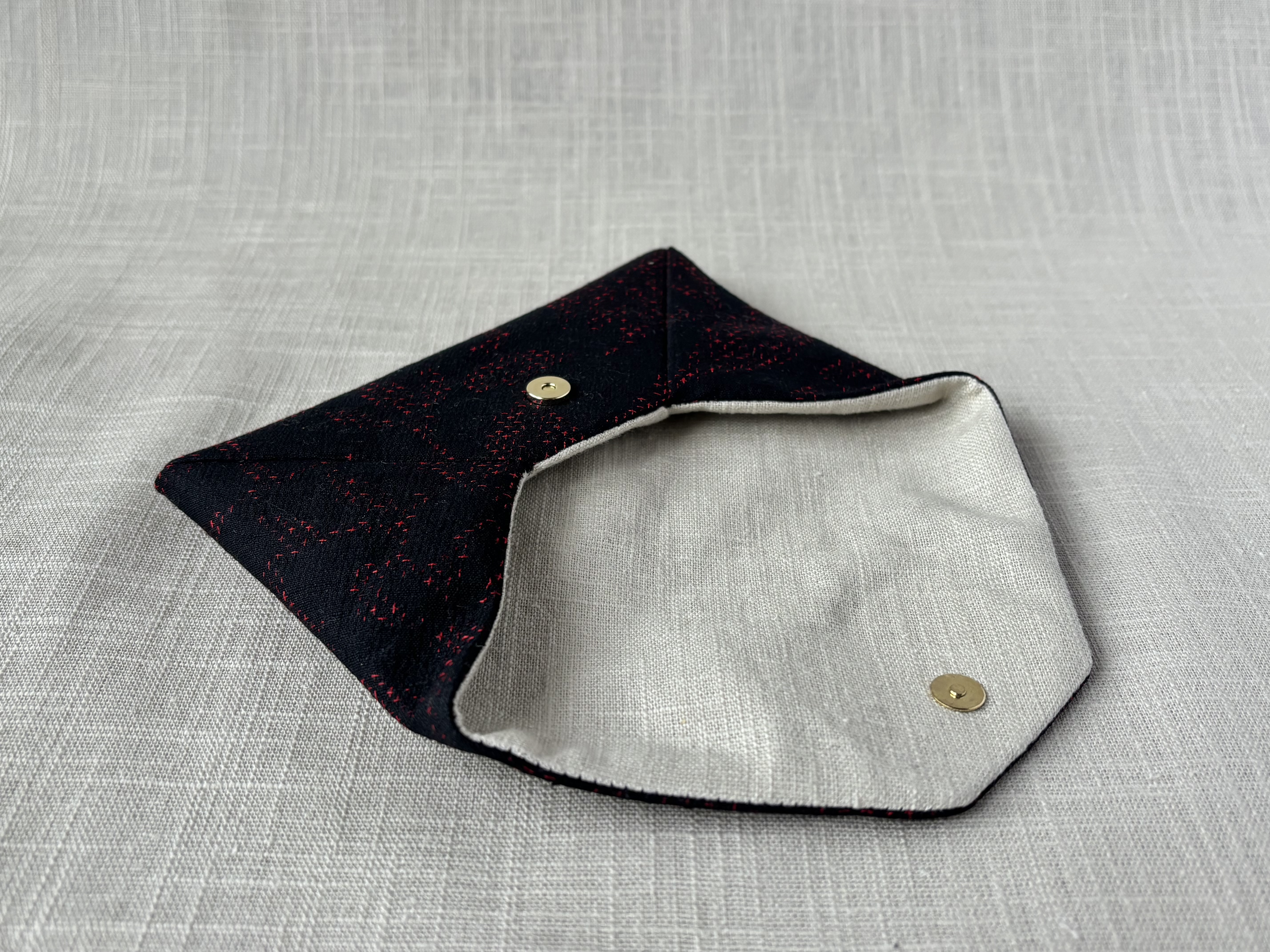 Side view of the sukiya bag with open flap, showing the interior lining of a natural linen cotton blend.